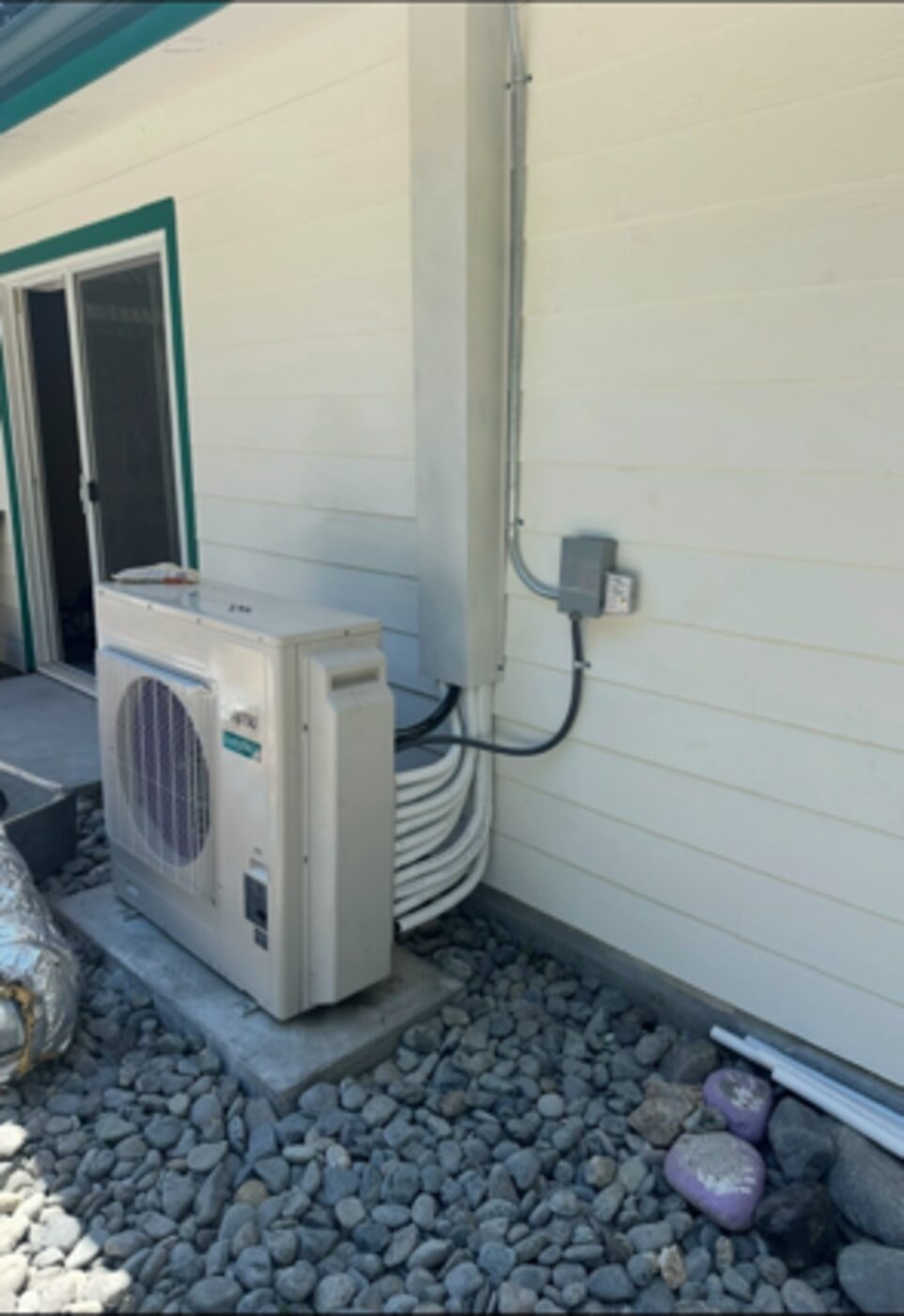 Mini-split condenser set on a pad at an Anderson CA residence